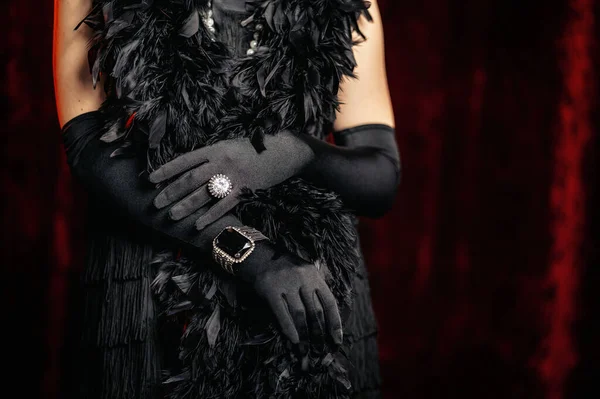 Mulher bonita em pé no século 20 histórico velho em vestido flapper com franja, penas boa em fundo vermelho. Detalhes do traje Gatsby, jóias do tesouro . — Fotografia de Stock