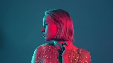 Gizemli yeniyetme. Bin yıllık güzel bir kızın portresi. Kısa saçlı, neon ışıklı. Boyalı mavi ve pembe saçlar.