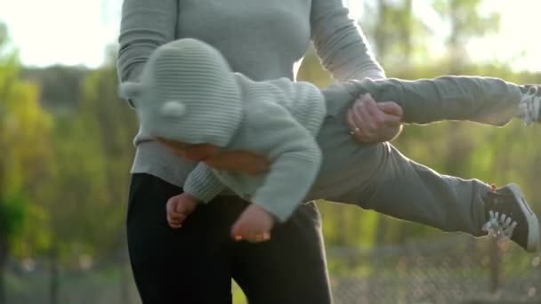 幼い母親が遊び、幼い男の子を抱きかかえている。母さんは息子に腕を回している。愛、家族、ケア、親の概念. — ストック動画