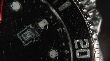 Japon kronografı, safir camlı metal üretti. Bilek saati - yavaş çekim, zaman yavaş geçiyor - camda küçük su damlalarıyla güzel bir makro çekim