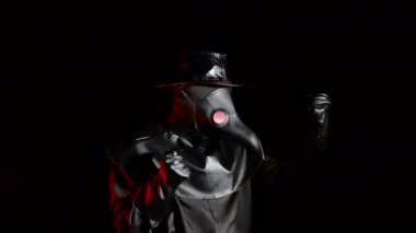 Veba doktoru kostümlü, karga gibi maskeli bir adam evet işareti yapıyor, siyah arka planda izole edilmiş bir şekilde seviniyor. Ürkütücü maske, tarihi kostüm konsepti. Salgın