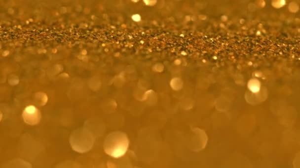 墨色で金色の粒子をきらびやかに。黄色の金は円形の顔を焦点を当てた。自然界の浮遊有機物の概要粒子。背景。クリスマスと明けましておめでとうございます。スローモーション. — ストック動画