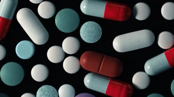 Thème pharmacie. Pilules et capsules isolées multicolores tournant sur la surface noire. Vitamines, concept de drogue. COVID-19, Coronavirus, épidémie 