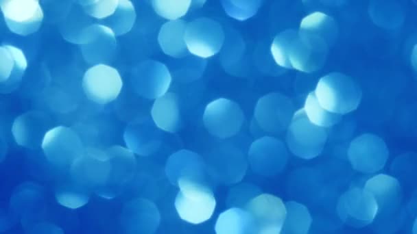 Absztrakt háttér ragyogó kék bokeh csillogás. Ragyogó részecskék. Defokált körkörös facula. Természetes úszó organikus elvont háttér. Karácsony és boldog új évet. — Stock videók