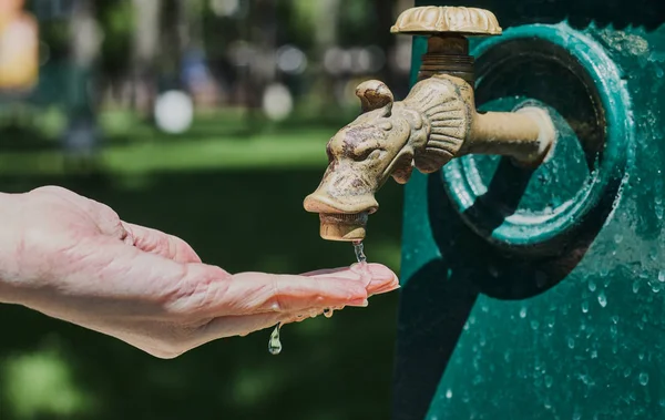 Washing your hands under the faucet in the park