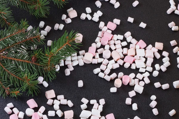 Small marshmallows scattered on a black background — Stock Photo, Image