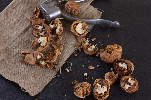 Nueces y cascanueces en la mesa cubierta con arpillera — Foto de Stock