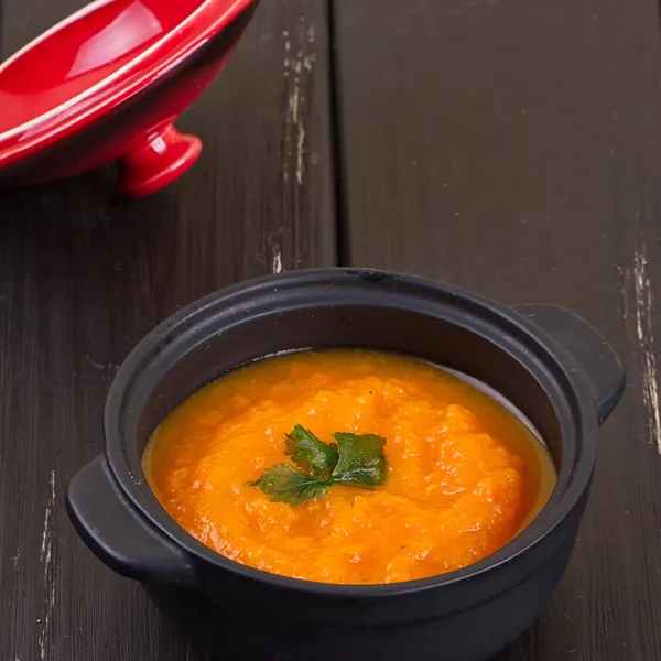 Pumpkin soup in a small black pot — Stock Photo, Image