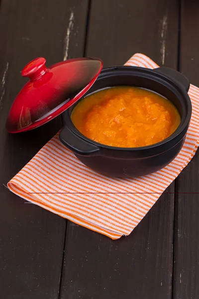 Pumpkin soup in a small black pot — Stock Photo, Image