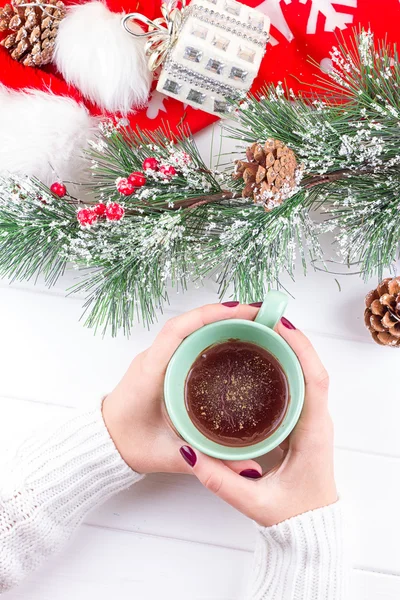 Filles mains tenant chocolat chaud sur table blanche avec des décorations de Noël — Photo