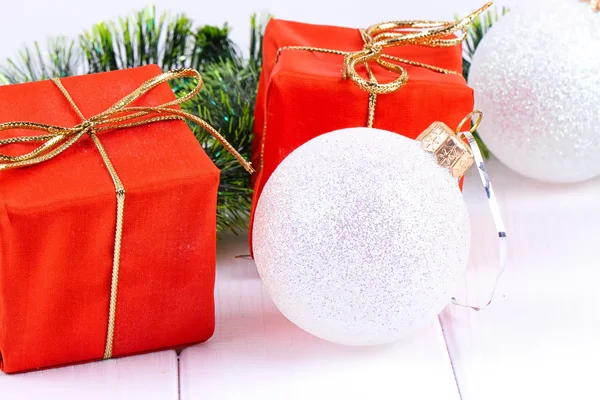 Box with christmas gifts and decorations on a white wooden background — Stock Photo, Image