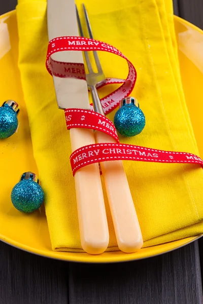 Fondo de Año Nuevo de Navidad. set tenedor, cuchillo, cuchara en servilleta amarilla con decoración Cinta de oro de vacaciones, bola azul —  Fotos de Stock