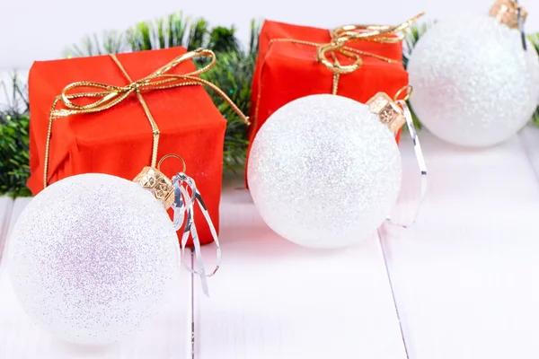 Scatola con regali di Natale e decorazioni su sfondo bianco in legno — Foto Stock