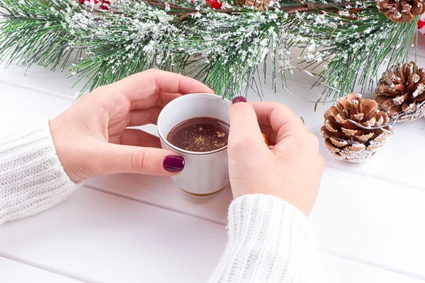 Filles mains tenant chocolat chaud sur table blanche avec des décorations de Noël — Photo