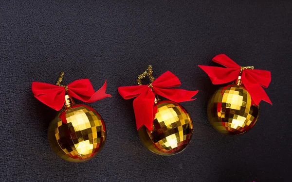 Gold Christmas balls with red ribbons — Stock Photo, Image
