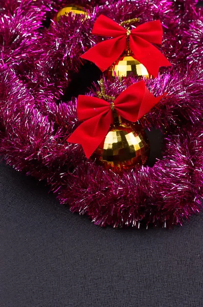 Guld julgranskulor och ljusa glittrande gyllene glitter med röda rosetter — Stockfoto