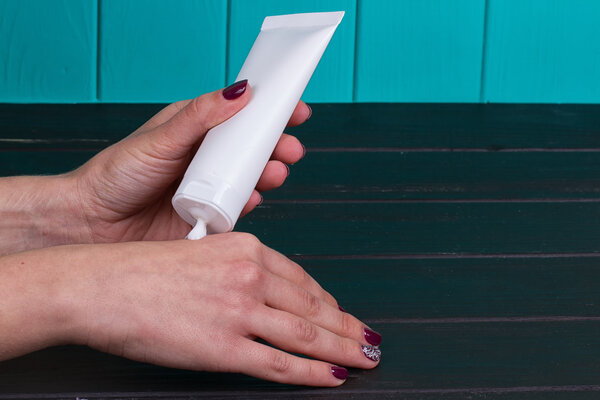 Female hand cream squeeze out of tube