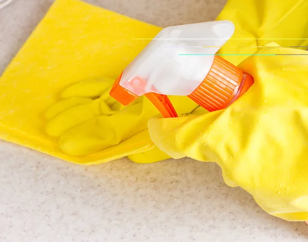 Hand in rubber glove cleans a new kitchen