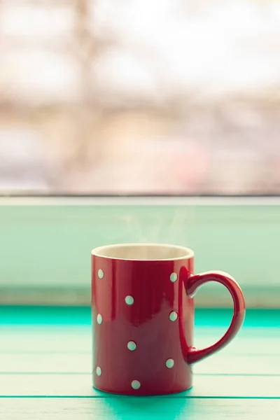 Красная чашка в белом горошке — стоковое фото