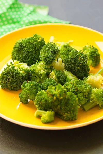 Fresh broccoli cut in yellow plate — Stock Photo, Image