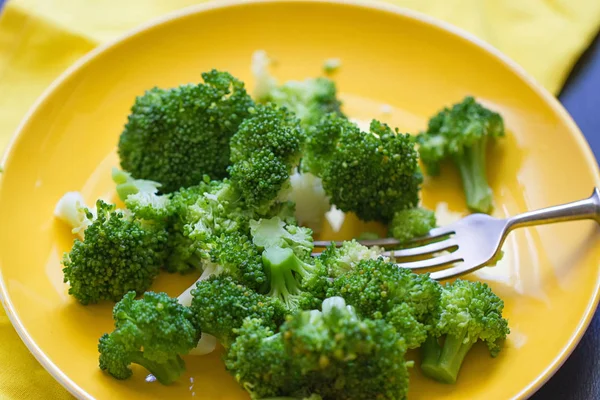 Fresh broccoli cut in yellow plate — Stock Photo, Image