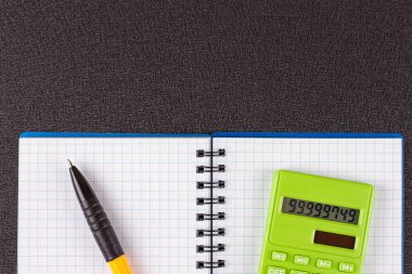 Hesap makinesi ve ahşap zemin üzerine kalem