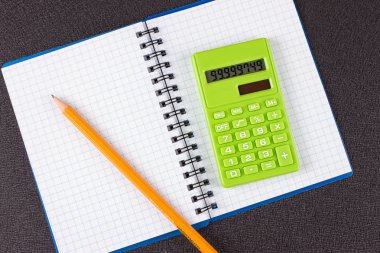 Hesap makinesi ve ahşap zemin üzerine kalem