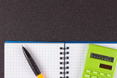 Hesap makinesi ve ahşap zemin üzerine kalem