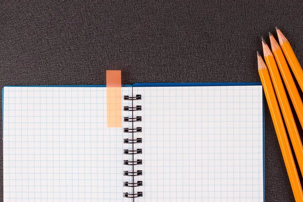 Άνοιξε το σημειωματάριο και πολύχρωμα μολύβια σε μαύρο φόντο — Φωτογραφία Αρχείου