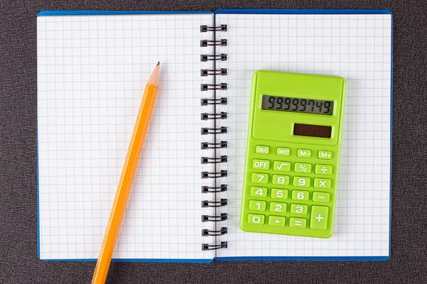 Hesap makinesi ve ahşap zemin üzerine kalem