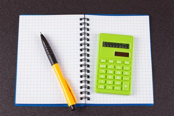 Hesap makinesi ve ahşap zemin üzerine kalem