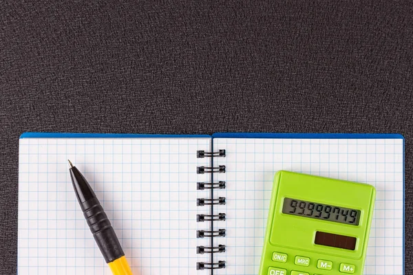 Hesap makinesi ve ahşap zemin üzerine kalem