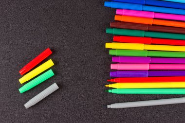 Siyah arkaplanda renkli kalemler