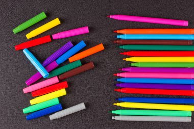 Siyah arkaplanda renkli kalemler