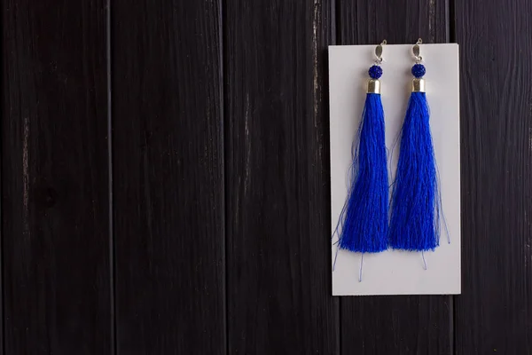 Small white leather woman's backpack and blue earrings of thread — Stock Photo, Image