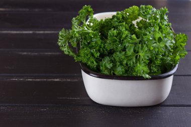 Bir demet taze maydanoz içinde siyah bir zemin üzerine Seramik Tepsi.