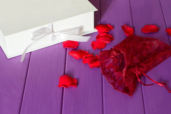 Pétalos de rosa y caja regalo — Foto de Stock