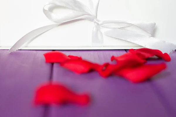 Pétalos de rosa y caja regalo — Foto de Stock