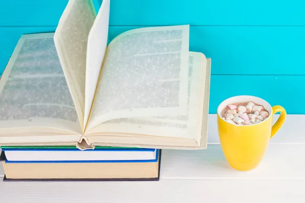 Pilha de livros na mesa de madeira com uma xícara de chá — Fotografia de Stock