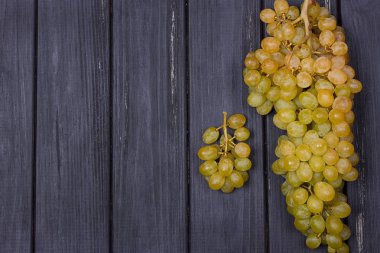 siyah bir ahşap zemin üzerine beyaz üzüm demet