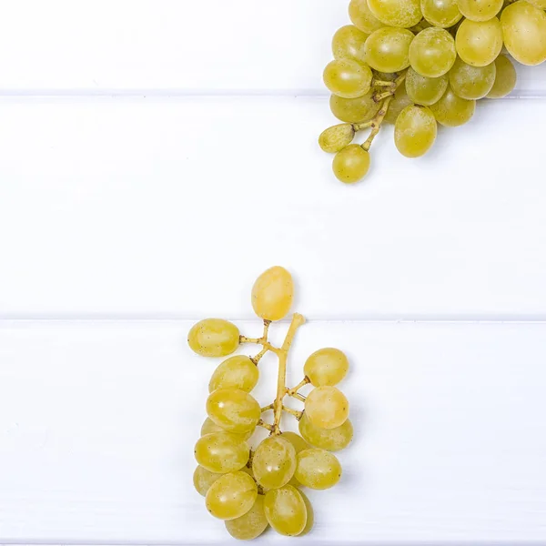 Raisins blancs sur la surface en bois blanc — Photo
