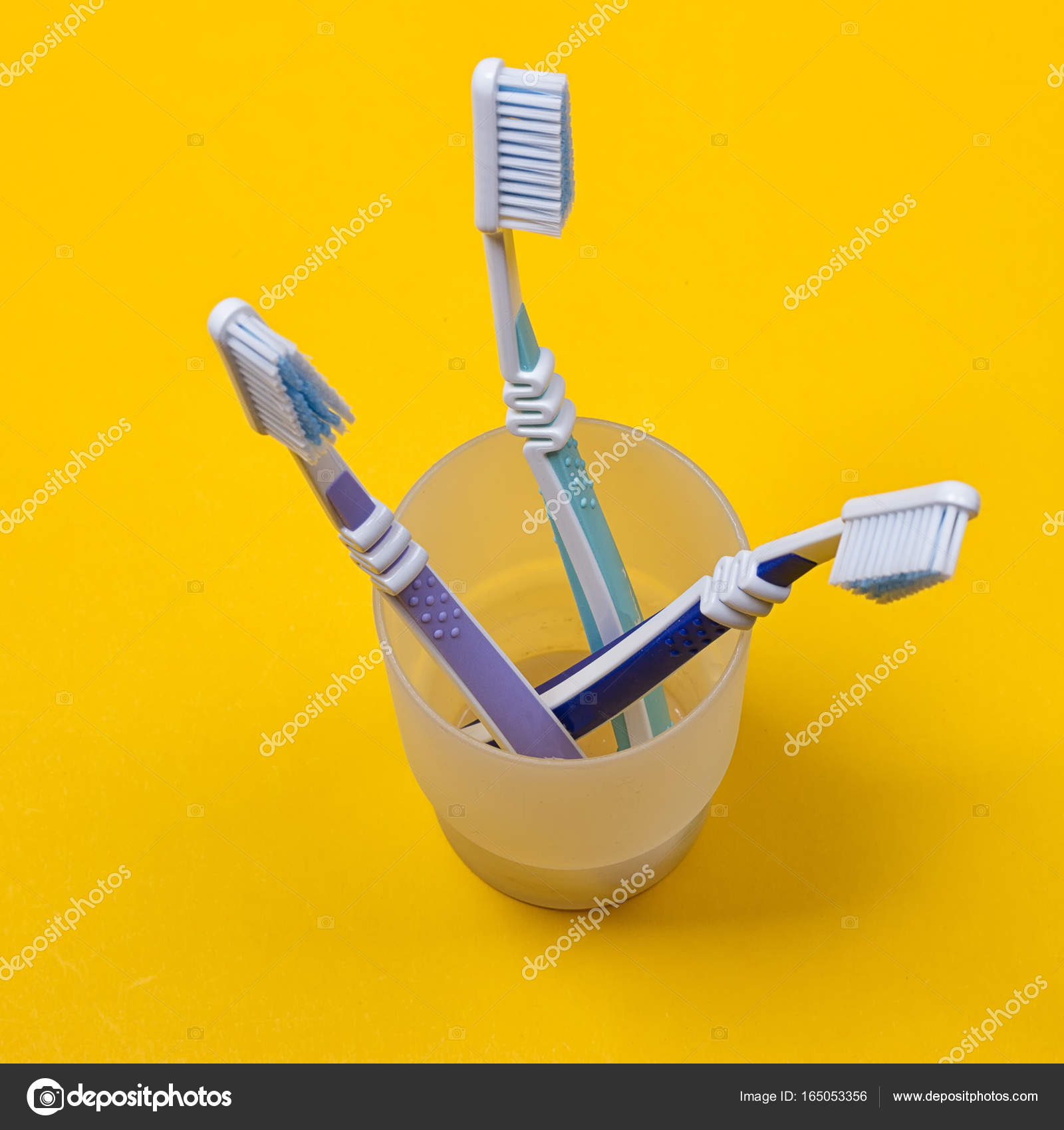 Pincel de dientes amarillos y una pasta de dientes en un fondo rosa