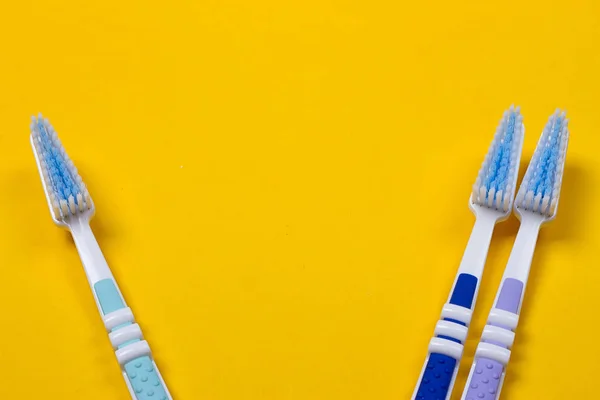 Three Toothbrushes on yellow background — Stock Photo, Image