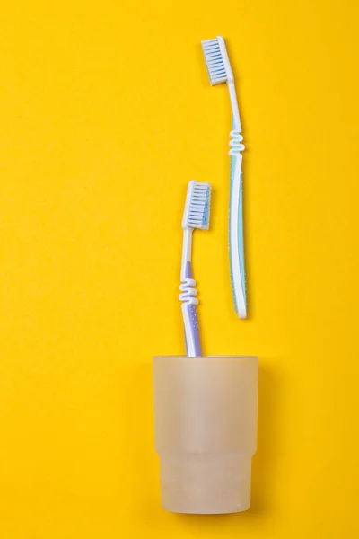 Toothbrushes on yellow background — Stock Photo, Image