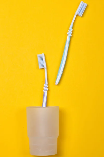 Toothbrushes on yellow background — Stock Photo, Image