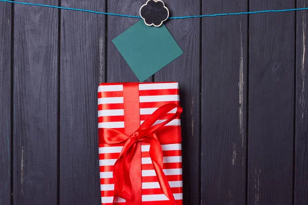 Caja de regalo con lazo rojo sobre fondo de madera —  Fotos de Stock