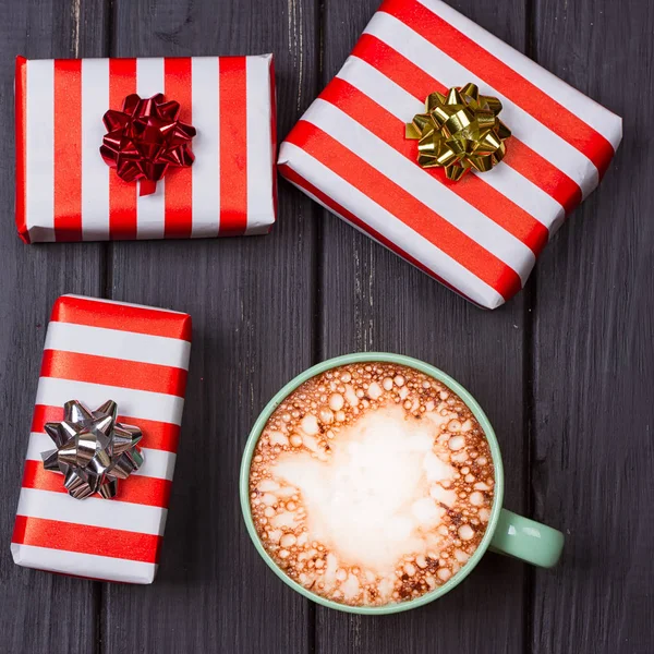 cup of hot cocoa or chocolate with marshmallow and gift boxes