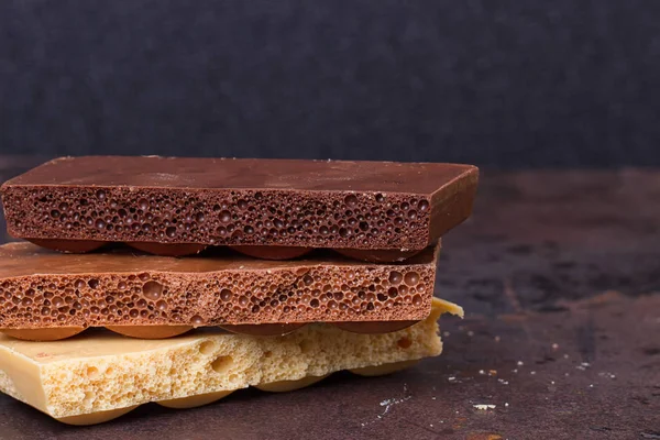 Stos różnych rodzaju porowatych kawałków czekolady — Zdjęcie stockowe