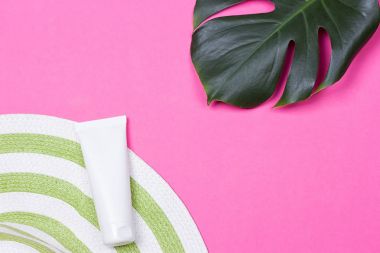 güneş gözlüğü ve hasır şapka ile yeşil monstera yaprak