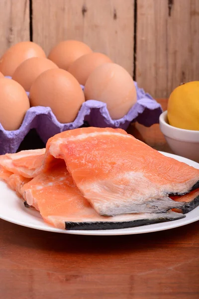 Filetto di salmone fresco da vicino su piatto bianco. uova e limone — Foto Stock